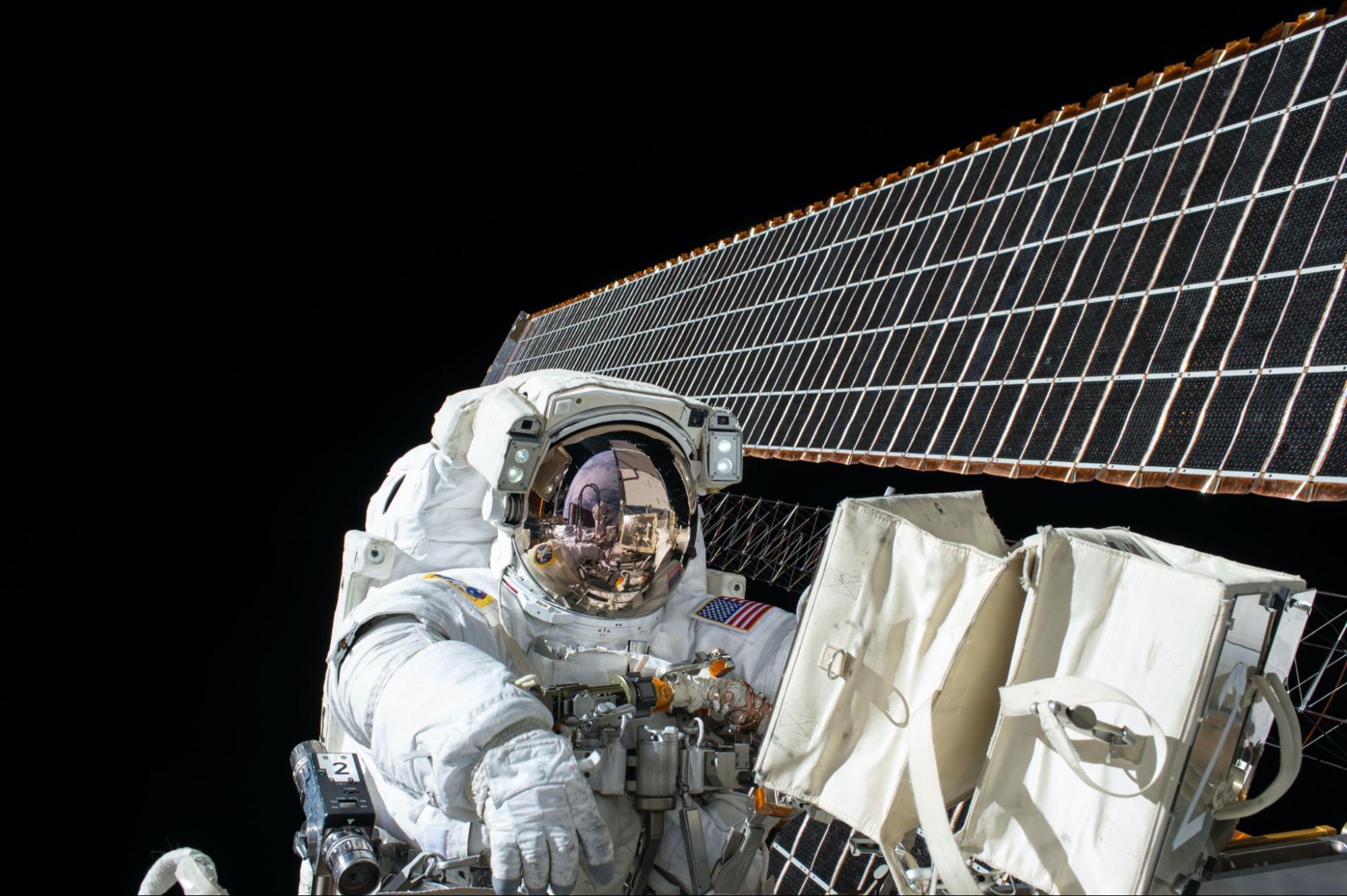 Astronaut in space operating on solar panels